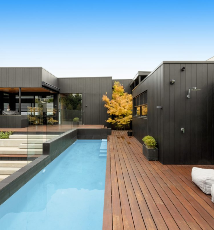Home with pool and weatherboard exterior cladding in black